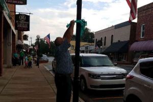 Blissfield Michigan Man Tying Ribbon On Lamp Post