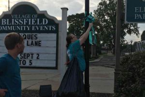 Blissfield Michigan Woman Tying Ribbon On Lamp Post